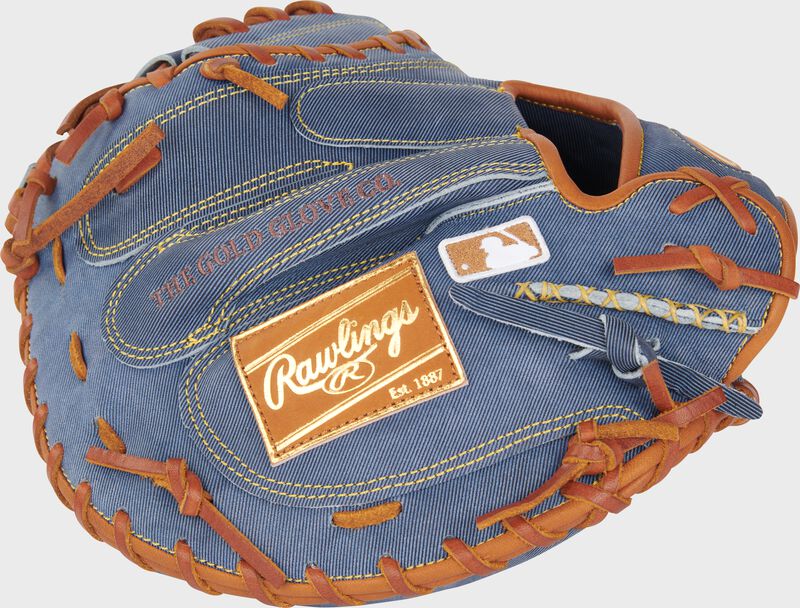 Back of a Heart of the Hide Pro Label Denim catcher's mitt with a tan leather Rawlings patch and MLB logo on the pinky loading=