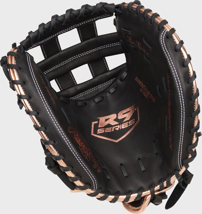 Black palm of a Rawlings R9 Series fastpitch catcher's mitt with rose gold stamping and black laces  loading=