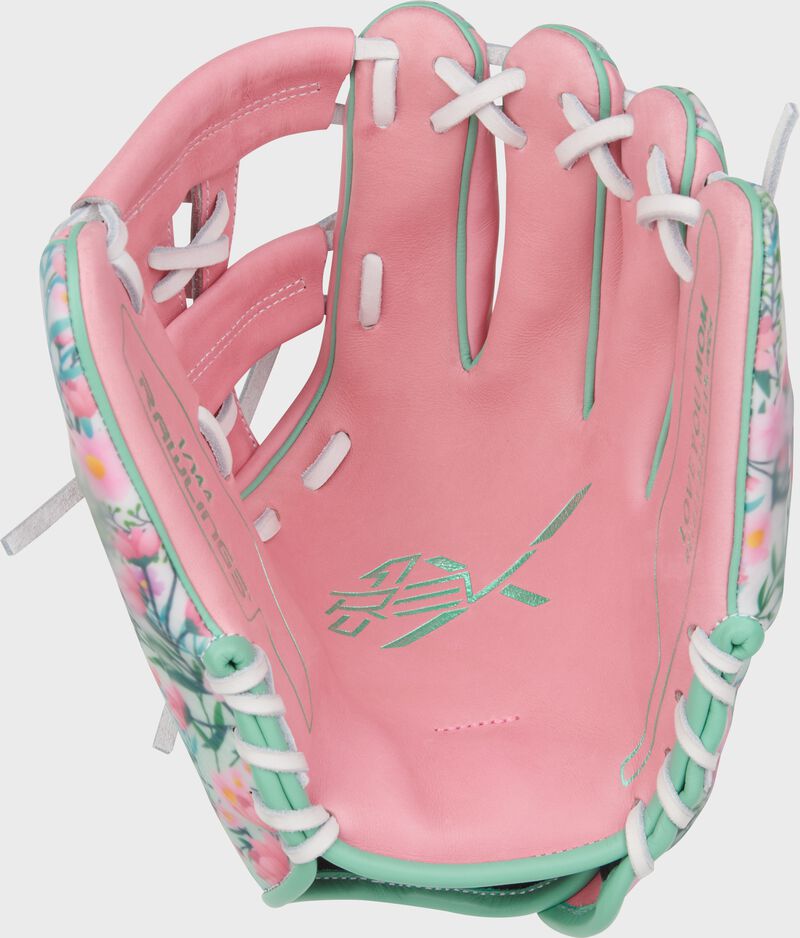 Pink leather palm of a Rawlings Mother's Day REV1X glove with white laces loading=